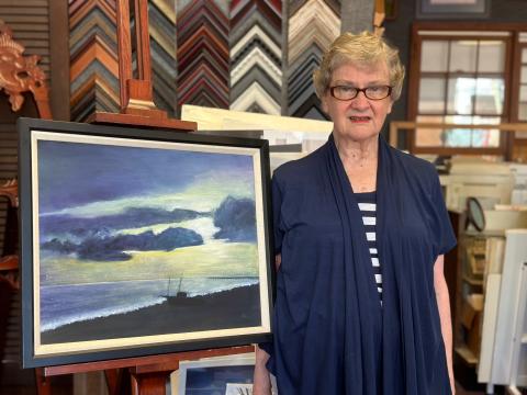 Louise Bisso with one of her paintings, inside ElsieBee Originals. 