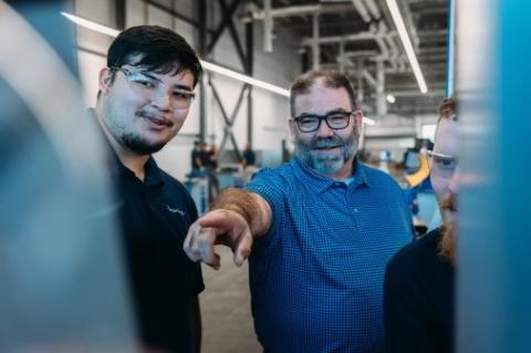 Haering Precision`s Academy Manager Tim Bennett (center) working with machining apprentices.