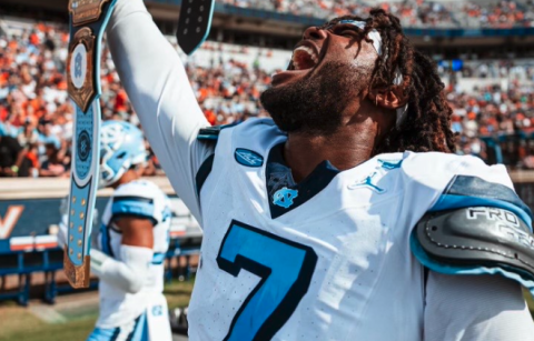 Former Bulldog and current UNC defensive end Kaimon Rucker holds up the UNC WWE turnover belt after collecting an interception in the Tar Heels 41-10 win in Charlottesville against the Cavaliers of Virginia. Photo by UNC Athletics.
