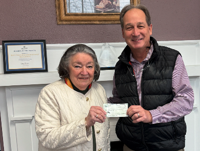Christina Silpe (left) from Hart Interdenominational Ministries (HIM) receives a $2000 check from Lowell Macher, President of the Hart County Property Owners Association during their Holiday Harvest Fundraiser Nov. 23.  
