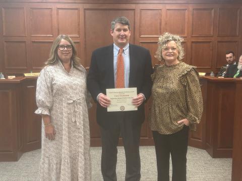 Hart County athletic director and head football coach Cory Dickerson (middle) was honored at the Board of Education meeting on Dec. 9. Also pictured is Kim Pierce (left) and superintendent Jennifer Carter (right).