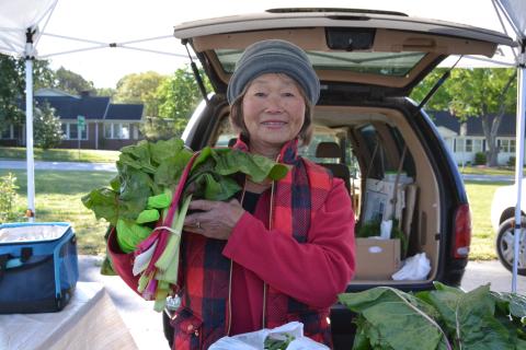 May Workman holds homegrown swiss chard during the opening weekend of the Hartwell Farmers Market April 12. Workman has been selling at the market for 22 years and sells berry plants, greens, carrots and other vegetables. (Photo/Adriana Cascio)