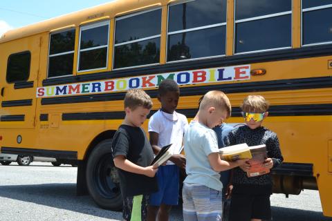 Children at the Hart Youth Development Resource Association (HYDRA) show off their books to each other outside the Hart Partners Bookmobile on Tuesday. The Bookmobile provides free snack bags and books for all children age groups, from toddlers to teenagers, throughout Hart County. (Photo/Adriana Cascio)