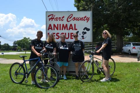  Hart County Animal Rescue (HCAR) employees and volunteers (L-R) Robert Sterling, Kristi Sterling, Sherri Lane, Maycee Lane and Lisa Oliphant pose with bicycles in front of the HCAR sign. The group is participating in 100 days of walking, running and cycling to raise awareness for the organization and struggling dogs in the Hart community. (Photo/Adriana Cascio)