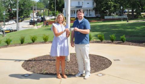 The Toccoa Record Publisher Michael O’Hearn, right, presents Kim Caudell of Toccoa with the $100 she won for her photo in the 2025 summer Lake Living cover contest. (Photo by J. Todd Truelove, The Toccoa Record)