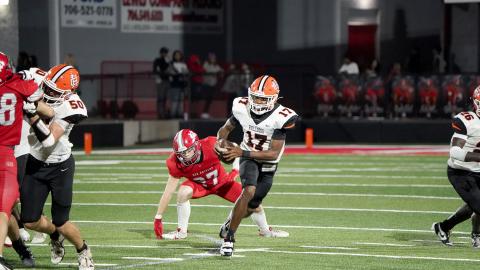 Junior quarterback Kurston Curry evades the pressure from the Red Raiders defense in the 28-14 loss to Madison County Aug. 22. (Photo by Ric Williams)
