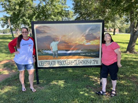 Minister leader Stephanie Carey (left) and volunteer Tammy Lampp (right) pose in front of the Celebrate Recovery sign outside of Cornerstone Baptist Church, located at 1543 Anderson Highway. Celebrate Recovery is a program dedicated to servicing those recovering from drugs, alcohol, depression, overeating and other addictions. (Photo submitted by Stephanie Carey)