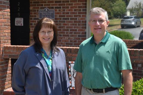 Nurse Lisa Walters (left) and Dr. JoDon Garringer (right) pose together in front of Hartwell Family Practice, located at 229 Athens St., on Sept. 3. Garringer said he and Walters have developed a brother-sister relationship, after watching their families and careers grow alongside each other. (Photo by Adriana Cascio)