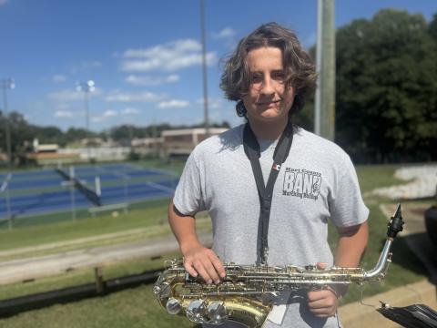 Sophomore saxophonist Henry Waters smiles and holds his instrument at attention after being named member of the week for this week’s High Notes series. Waters was not only recognized for his ability to stay in step, but also for always moving the band’s equipment. (Photo by Adriana Cascio)