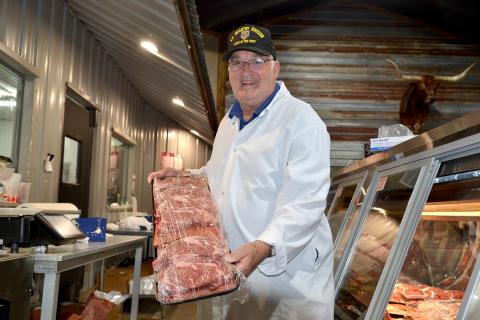 Winston Phillips, who has spent nearly six decades working in five different butcher shops, presents a tray of ribeyes, his favorite cut of meat, at Hometown Butcher.  (Photo by Adriana Cascio)