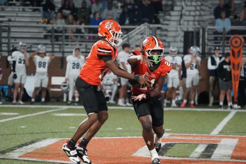 Junior quarterback Kurston Curry (left) fakes the hand off to his junior running back Faustino Rangel (right) before running a quarterback keeper in the 21-6 win over the Eagles of East Jackson Oct. 17. (Photo by Ric Williams)