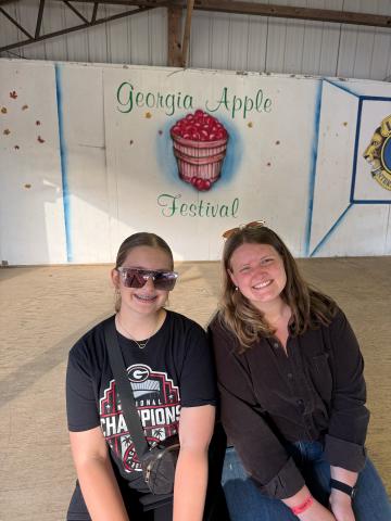 The final stop on our grand fall adventure Saturday was Ellijay’s Georgia Apple Festival. My cousin, Chloe Peace (left), and sister, Marlie Scoggins (right) posed for a photo in front of the festival stage. (Photo by Rose Scoggins)