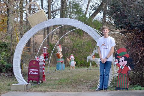 Hart County High School 11th grader Tyler Bowers stands in front of the entrance to his light display on Cedar Creek Circle. The display celebrates a decade of bringing Christmas cheer to the community.