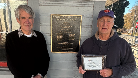 TORCH board member Larry Torrence (left) surprised outgoing fellow board member Lenford Smith (right) with a plaque for his years of service to the board. Photo by Rose Scoggins. 
