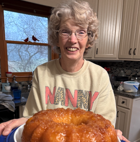 Nanny (Gail Leopard) holds our first creation this weekend – a pineapple juice cake. Photo by Rose Scoggins.