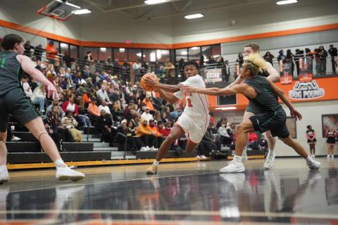 Senior guard Zaylen Shealer (left) drives to the basket against two Lion defenders, as he scores a career high 32 points in the 89-61 win over Franklin County Jan. 20. Photo by Ric Williams.