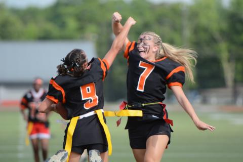 Seniors Hannah Jo Coker (left) and Erin Miller (right) celebrate after Coker’s second rushing touchdown in the 12-6 win over the Juniors in the annual Powderpuff game May 22. Photo by Benjamin London. 