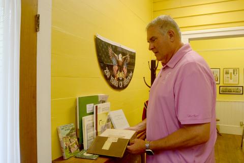 The Hart County Museum is located at 31 E. Howell St., in the Teasley-Holland House. Inside, museum-goers will find old artifacts donated from the public, such as the book Hart County Historical Society board chair Allen Stewart holds. They can also find AI-generated reworks of real, old photographs from Hart County's pre-consolidated schools and churches that allow them to be colorized and showcase similar-appearing people. Photo by Madison Linton.