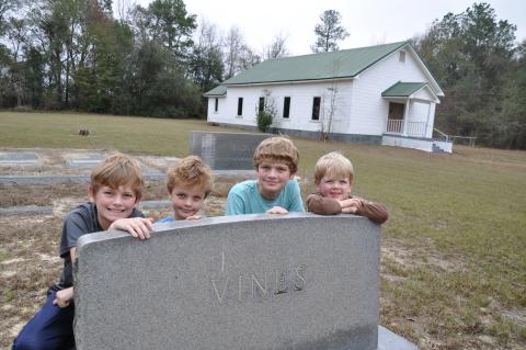 In 2017 four of our eight grandchildren visited the graves of their ancestors at Pilgrims Home Free Will Baptist Church on Hwy. 91 in Baker County, Georgia. The Wilsons are, from left, Hayes, Henry, Wyatt and Smith. They are posing by the granite tombstone of my mother’s parents, Howell and Essie (Nanny) Vines. Photo submitted by Dink NeSmith. 