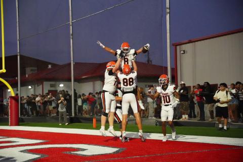 Offensive players celebrate with senior running back Kaidyn Allen (8) after scoring from 14 yards out, as the Dogs advanced to 2-0 with a 51-12 win over the Red Raiders of Madison County Aug. 28. Photo by Ric Williams. 