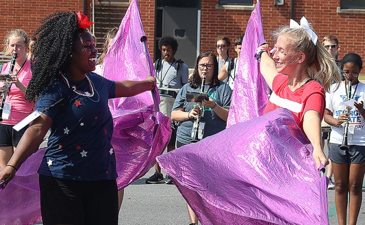 Flag corps members Detricunna Teasley, left, and Samantha Campbell, right, practice their flag routine during Hart County High School band camp on Monday.