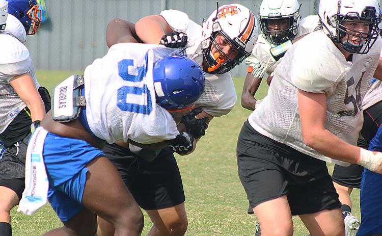 Hart County offensive lineman Caden Hart torques a Cedar Shoals defensive lineman last week at a full-contact camp in Habersham County.