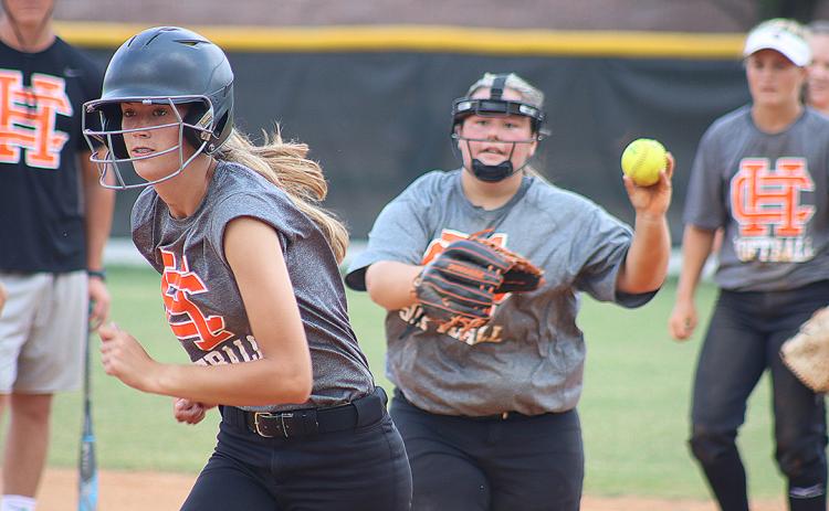 Sunshot by Grayson Williams — Freshman Emilee Sanders, left, tries to escape a pickle during a drill at Hart County High School softball practice Monday as Hannah Segars, right, tries to get Sanders out.