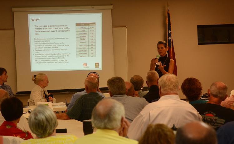 Sandy Campbell talks to property owners during a meeting about permit fee increases for shoreline activities.