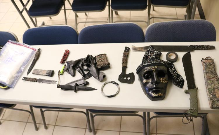 A bag of methamphetamine, at left, allegedly taken from a Hart County man, and knives, a hatchet, machetes, a mask and other items, allegedly taken from people out to kidnap and kill the man, are shown.