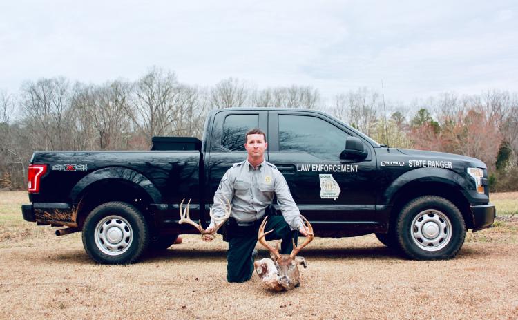 Sunshot by Grayson Williams — DNR Cpl. Craig Fulghum poses for a photo with a deer that was killed illegally.