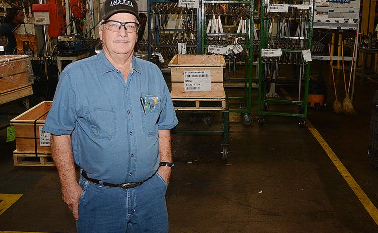 Sunshot by Michael Hall — George Adams poses for a photo in the factory at Tenneco where he has worked since 1959. He will retire when the plant closes later this year.