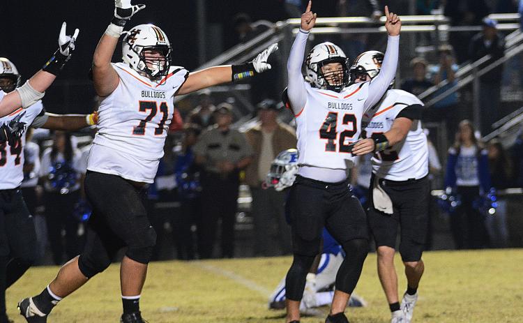 Sunshot by Michael Hall - Hart County kicker Tucker Kim, No. 42, raises his hands in victory along with Caden Hart, No. 71, while quarterback Luke Lee tackles Kim after Kim’s game winning field goal on Nov. 22 in Blackshear over the Pierce County Bears.