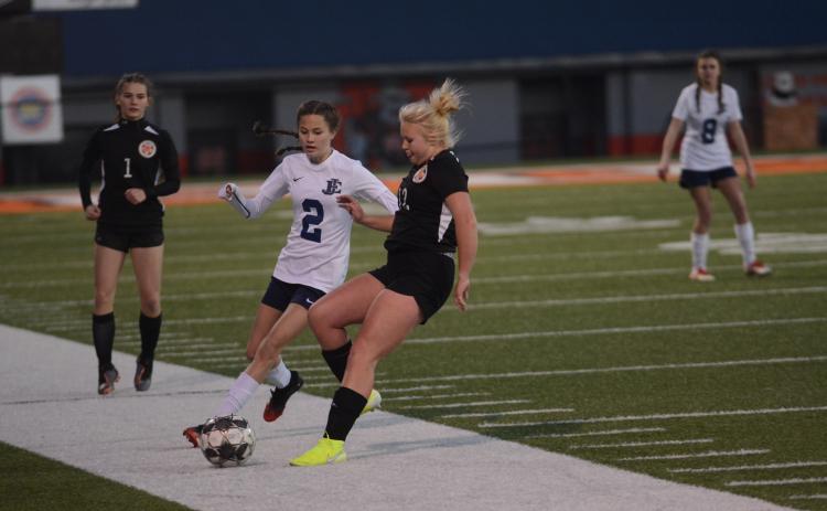 Sunshot by Grayson Williams - Skyler Chastain, right, battles for the ball with an East Jackson player on Friday, March 6 at Herndon Stadium as Evelyn Holmes, left, approaches.