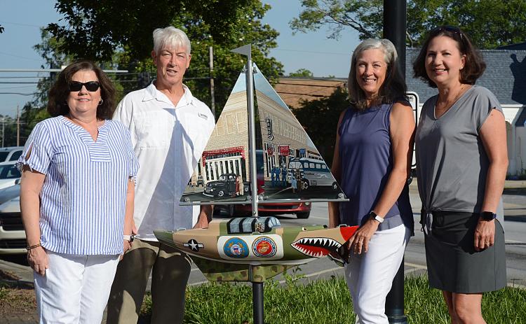 Sunshots by Michael Hall — From left to right, artist Debbie Gurley, Bo Howard, Tina Howard and artist Angela Short pose for a photo with the new sailboat installed Wednesday at Carolina and Howell streets to honor where service members boarded buses to go to World War II. The Howards spearheaded the fundraising for the project.