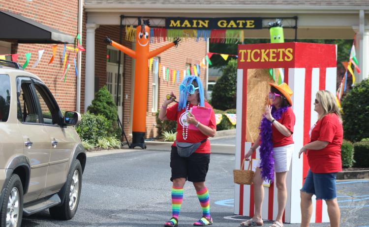 Sunshot by Grayson Williams Vacation Bible school teachers Jennifer Craft, left, Teresa Haygood, middle, and Kelie Worley, right are in costume pass out materials Thursday, June 18, at Hartwell First Baptist, to families participating in this year’s virtual VBS.