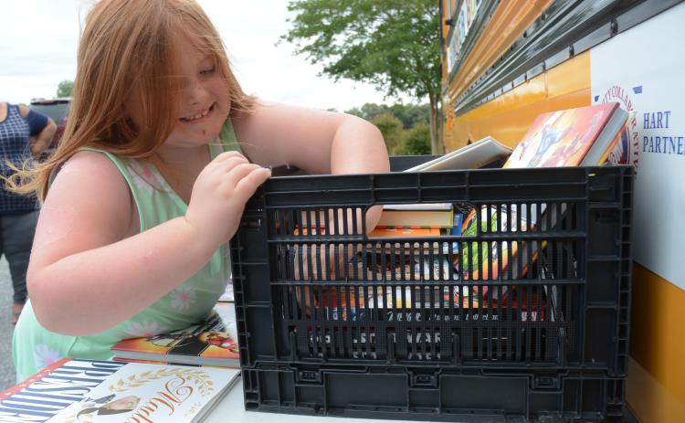 Photo from file — Emily Pickens, 7, finds a Star Wars book Tuesday, June 16, during a stop of the Hart Partners Summer Book Mobile at the Reed Creek Dollar General, for her brother Ethan, 11.
