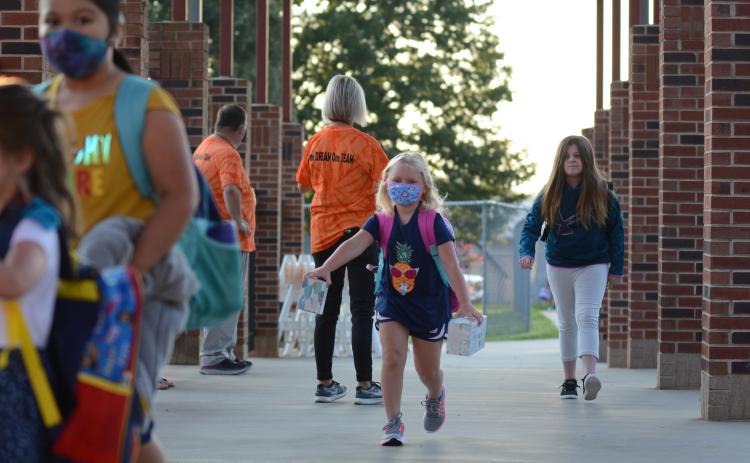 Sunshot by Michael Hall — Danica Kerr, middle, a first-grade student at Hartwell Elementary, runs to class after being dropped off at the school on Monday, Aug. 17 for the first day of the 2020-2021 academic year.
