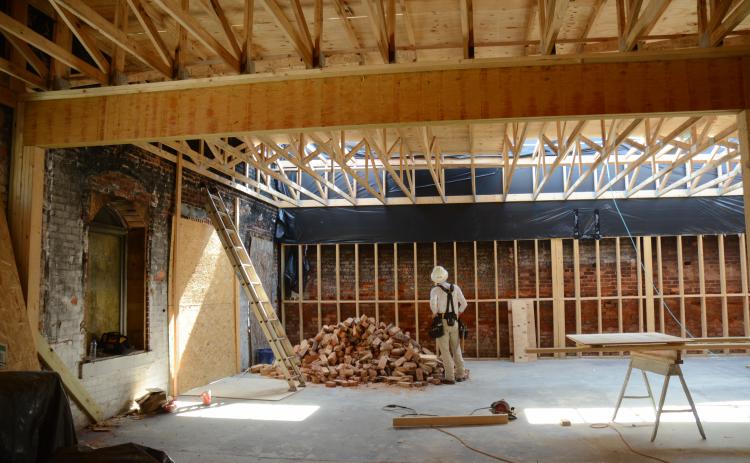 Sunshot by Michael Hall — A construction worker with J. Davis Construction stands inside the ongoing renovations at Little Japan in downtown Hartwell a year after the restaurant burned.
