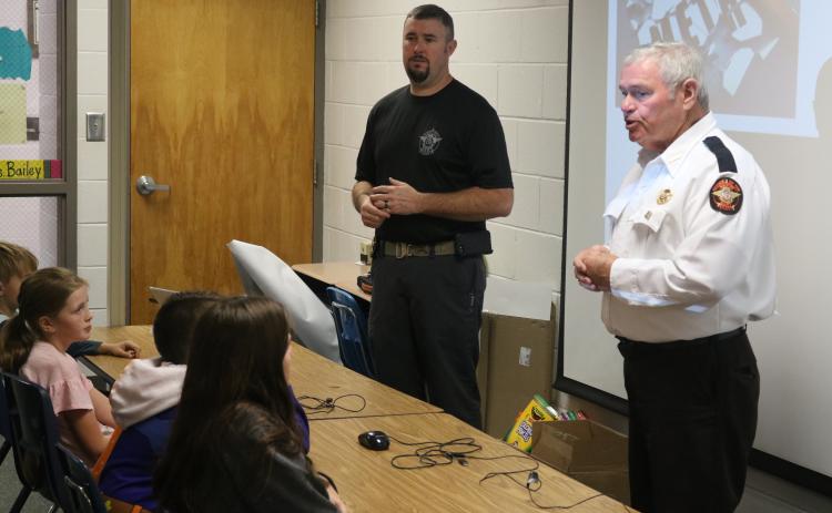 Sunshot by Grayson Williams - CHAMPS deputy Chris Carroll, left, and Hart County Sheriff Mike Cleveland speak to an elementary school class at South Hart Elementary School in 2019.