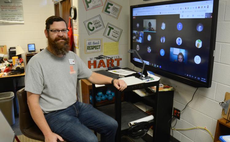 Sunshot by MIchael Hall - Josh McCurley poses for a photo at his virtual learning station where he is teaching third-grade virtual learners and will use a Bright Ideas Grant from Hart EMC to teach them circuitry.