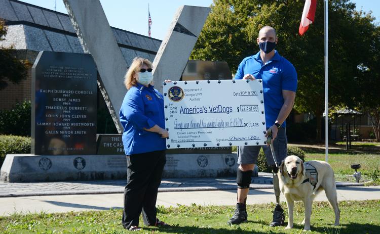 Sunshot by Michael Hall - Dawn Lemay, a Hartwell resident and state president of the Veterans of Foreign Wars Auxiliary, presents a check for $27,481.69 to Joe Worley, of America’s VetDogs, and his service dog Galaxie recently at the veterans memorial on the square at the Hart County Courthouse.