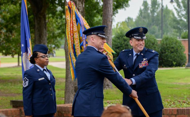 Col. Seth Graham, 14th Flying Training Wing commander, middle, hands Col. Jeffery Welborn, 14th Mission Support Group commander, right, the 14th MSG guidon at the 14th MSG change of command ceremony on July 13, 2020, at Columbus Air Force Base, Miss.