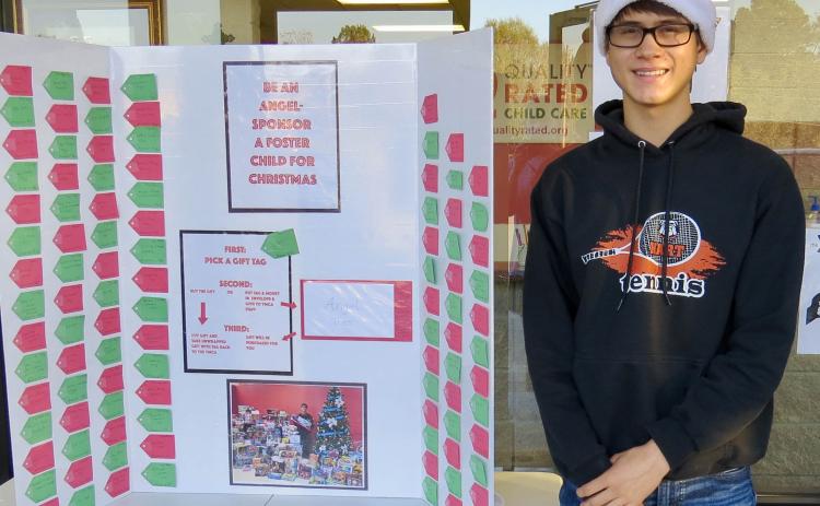 Photo submitted  - Ben Tellano poses for a photo with the Angel Tree display at the Bell Family YMCA recently.