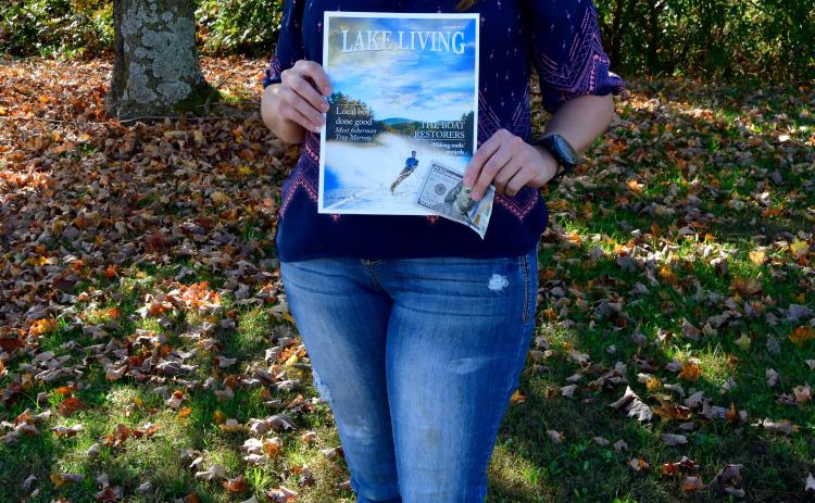 Photo by Kimberly Brown - Heather Conner, of Clayton, holds a copy of the cover of Lake Living Magazine and her $100 in prize money she won in a photo contest for the cover shot.