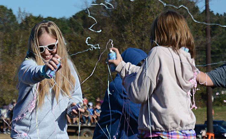 Brooklyn Vassar, left, and Mia Dancause, right, both fifth-graders, duel with cans of silly string during the Silly String Club Day activity.