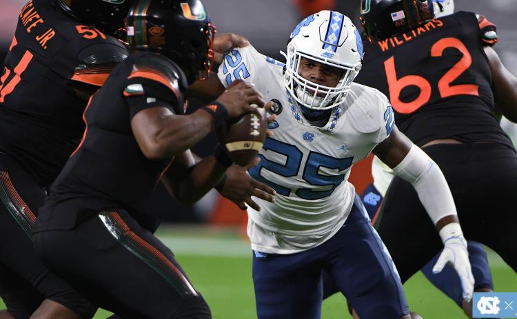 Photo from GoHeels.com - Hart County graduate Kaimon Rucker keeps his eyes on the football as he battles through Miami blockers trying to get to quarterback D’eriq King in Miami on Dec. 12.