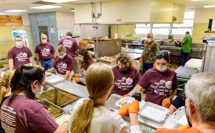 Volunteers put together Thanksgiving dinners during a recent event hosted by Love Him Love Them Ministries.