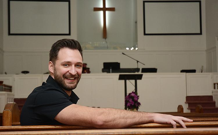 Sunshot by Michael Hall - Cross Roads Baptist Church pastor Sean Payne poses for a photo in the church’s sanctuary, which opened in 1920. The church is celebrating its 150th anniversary this year and is opening a new Family Life Center to mark the occasion on Feb. 14.
