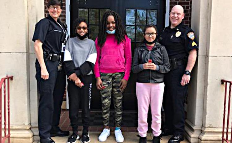 Pictured are officers Kay Ankerich, left, and Paul Agnew, right, with essay winners Chyna Orsley, from left to right in the middle, Audrey Harper and Sariyah Heard.