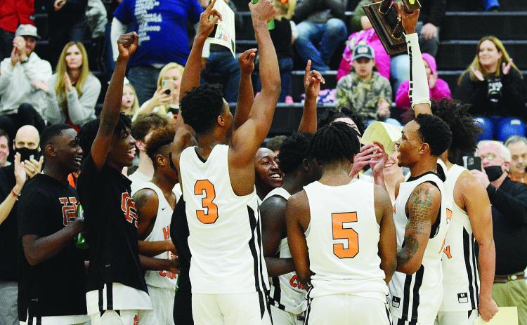 Sunshot by Michael Hall - Hart County senior Shone Webb, right, holds up the Region 8-AAA trophy on Saturday, Feb. 20, at Hart County High School after the Bulldogs defeated Monroe Area 61-52 to claim the school’s first boys’ basketball region championship since 2008.